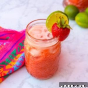Strawberry Limeade 11 Limonada de fresa in a glass, garnished with a strawberry and slice of lime