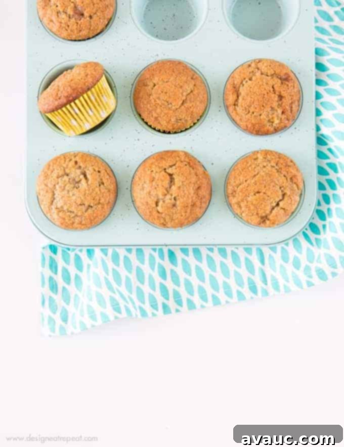 A plate with seven delicious, golden-brown banana muffins, some with colorful liners, showcasing their inviting texture.