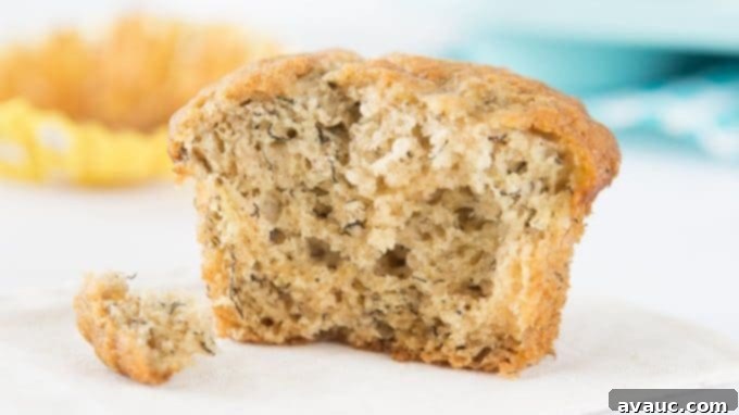 A pair of delightful banana muffins, one with a hint of a topping, presented invitingly on a rustic surface.