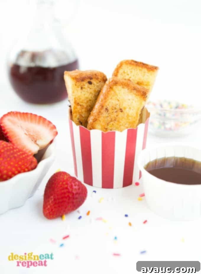 Striped red cup of homemade french toast sticks with strawberries and syrup