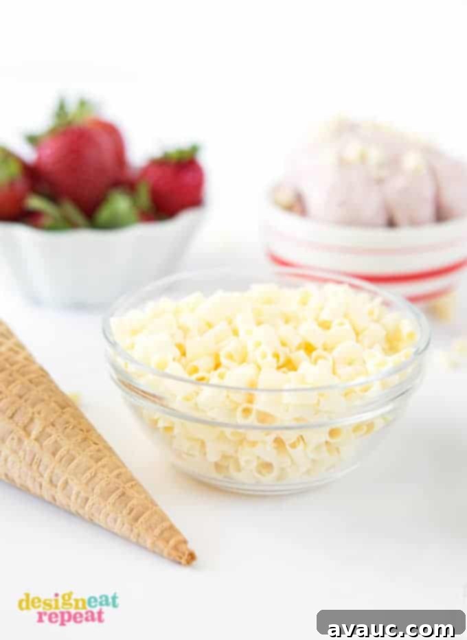 A scoop of homemade Strawberry Cake Batter Gelato in a bowl, ready to be topped.
