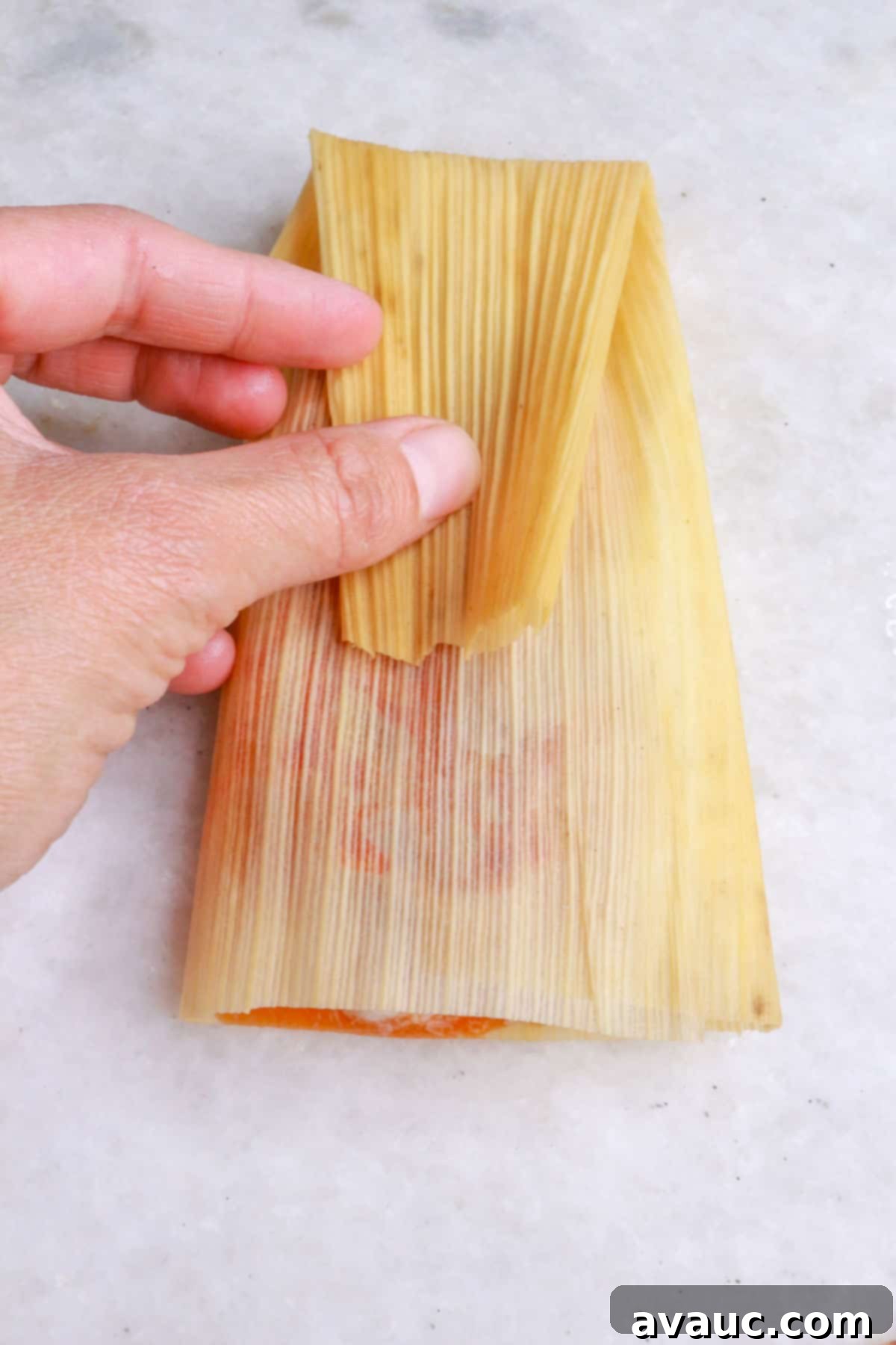 Red Chile Pork Tamales 11 Folding the narrow part of a tamal down
