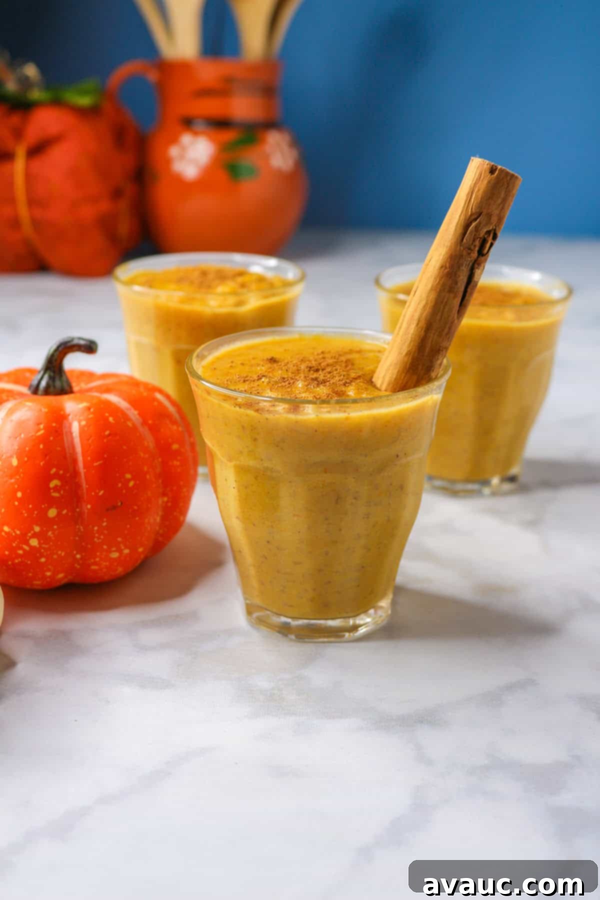 Pumpkin arroz con leche in a glass cup garnished with a cinnamon stick