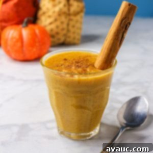 Pumpkin arroz con leche in a glass cup garnished with a cinnamon stick