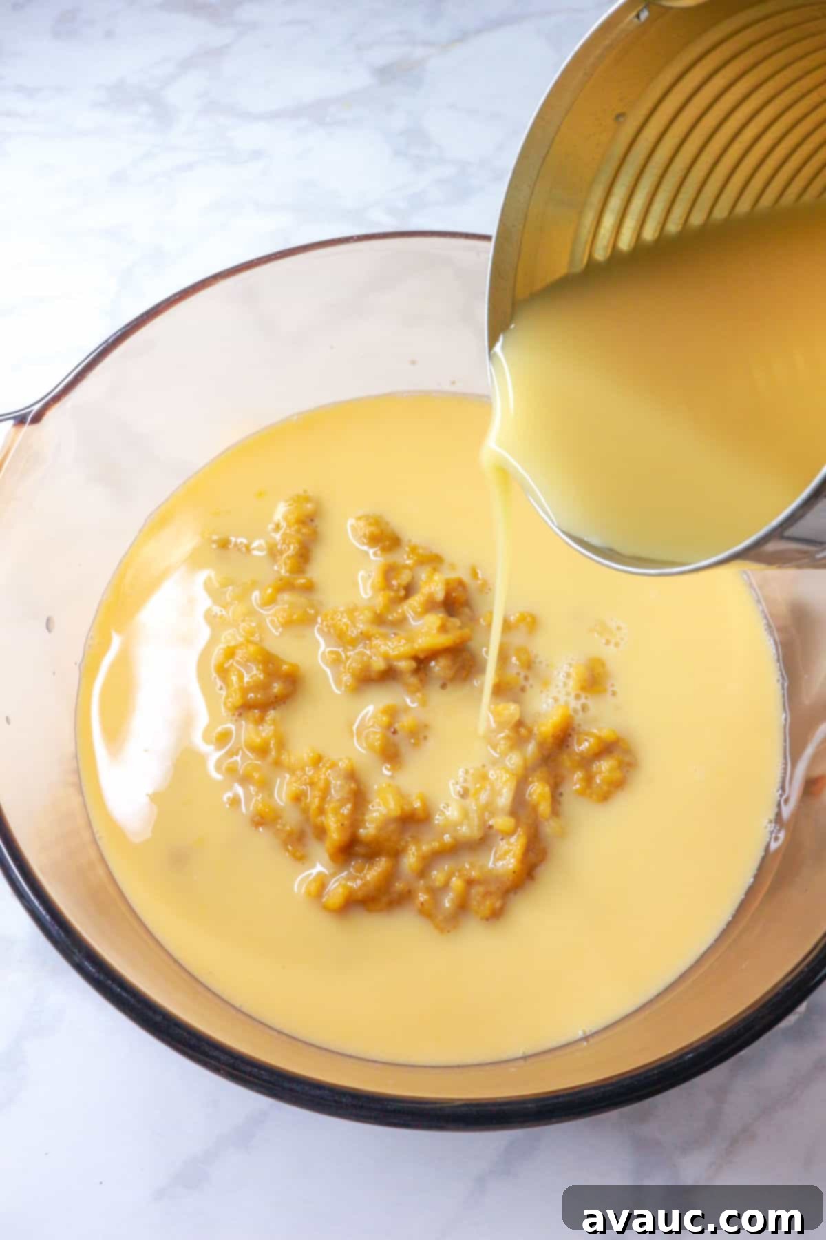 Pouring evaporated milk from a can to a pot with arroz con leche
