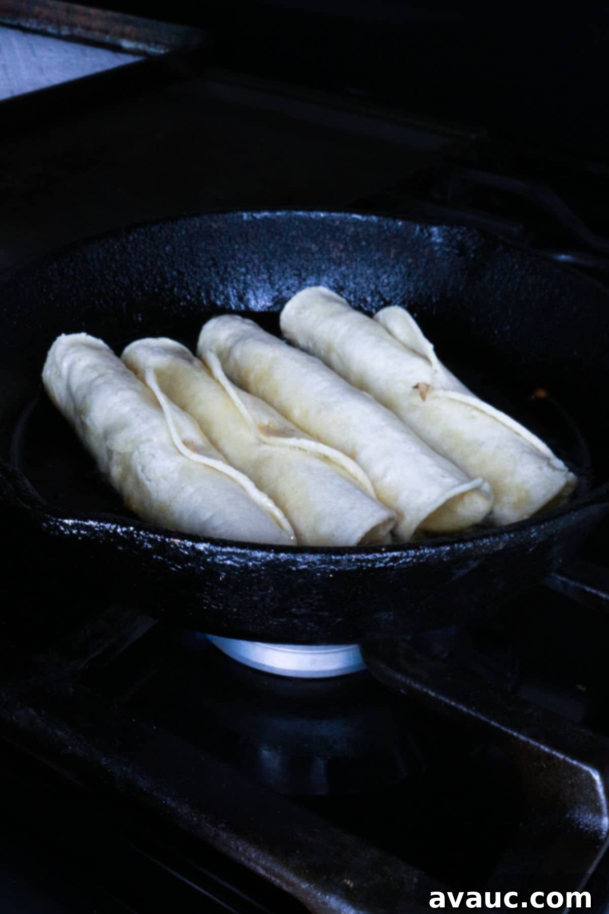 Crispy Rolled Chicken Tacos 7 Frying 4 flautas in a cast-iron skillet