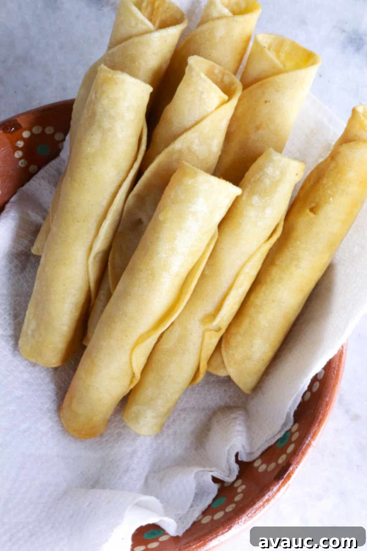 Crispy Rolled Chicken Tacos 8 Fried flautas standing upright in a bowl