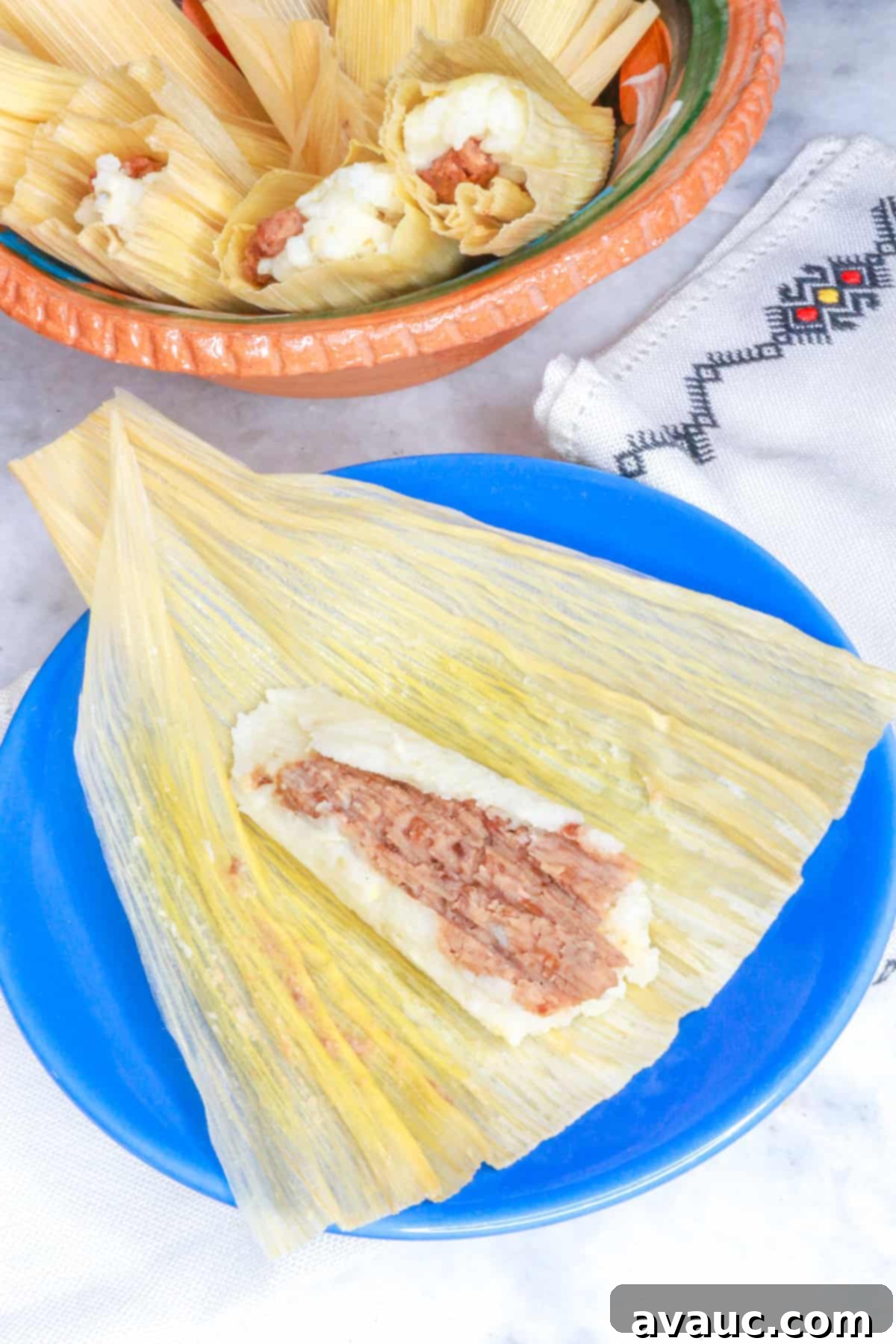 Savory Refried Bean Tamales 2 Tamales de Frijol, with one open bean tamal on a blue plate