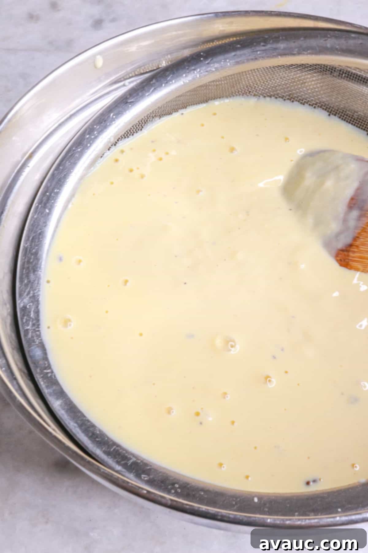 Rompope Mexicos Creamy Eggnog 9 Straining rompope through a fine-mesh sieve into a clean bowl
