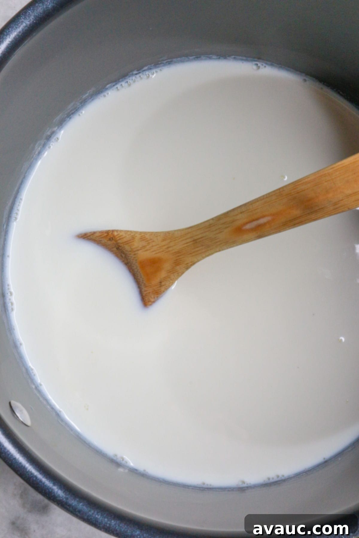 Rompope Mexicos Creamy Eggnog 4 Mixing milk with a wooden spoon in a large pot