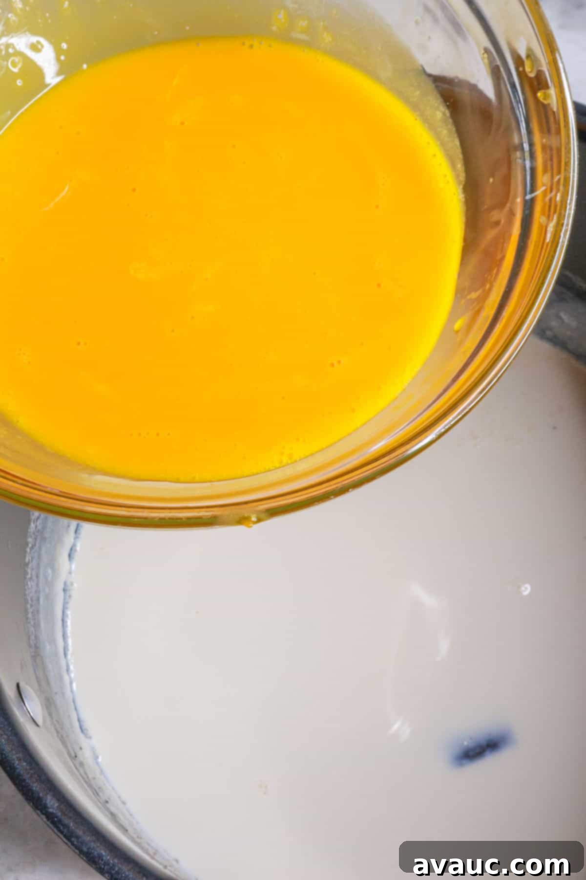 Rompope Mexicos Creamy Eggnog 7 Slowly adding warm milk mixture to whisked egg yolks to temper
