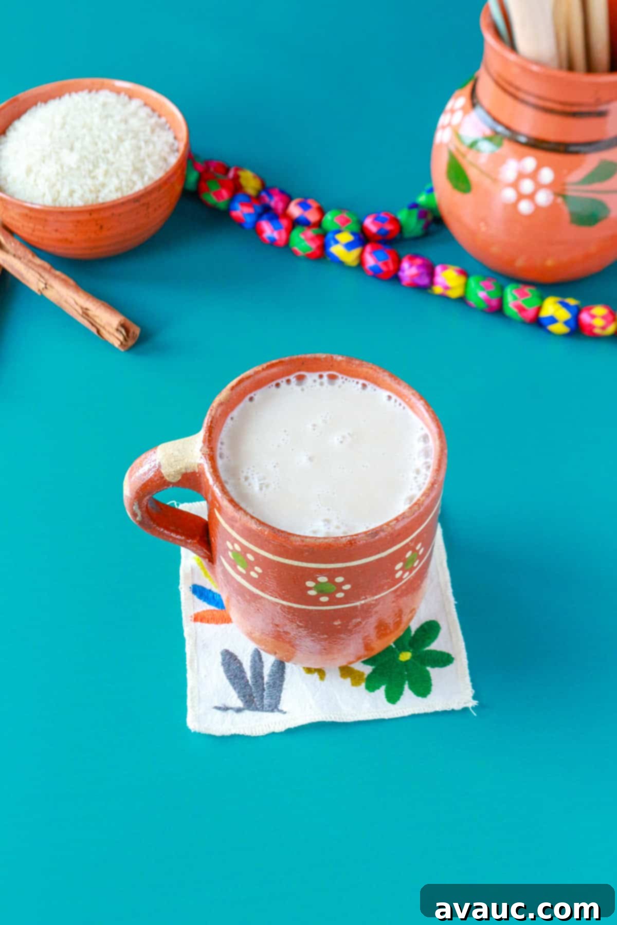 Creamy Rice Atole Dairy-Free Friendly 12 A Mexican mug with rice atole and a bowl of rice and a pitcher behind it