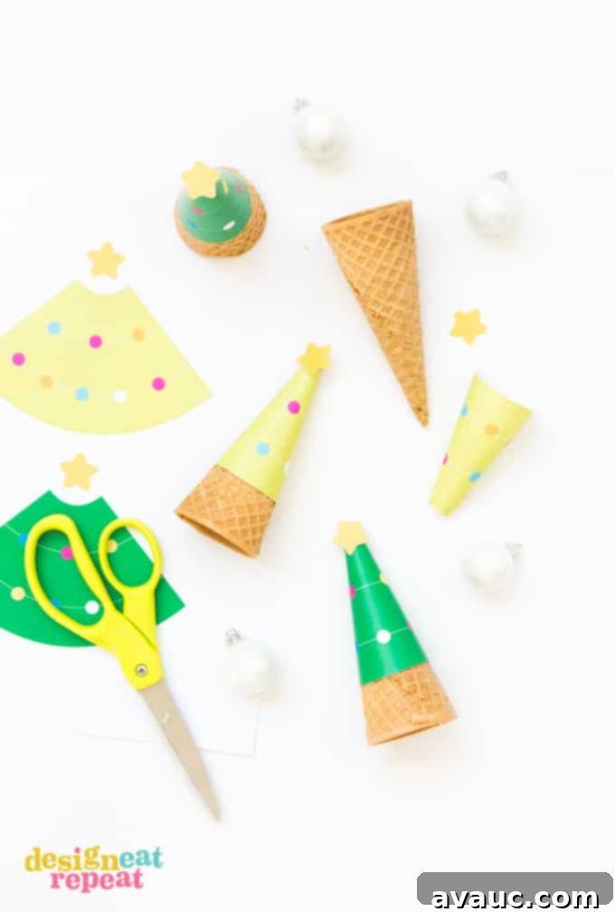 Printable Christmas Tree Cone Decorations 3 Hands holding a green Christmas tree ice cream cone wrapper against a background of festive bokeh lights