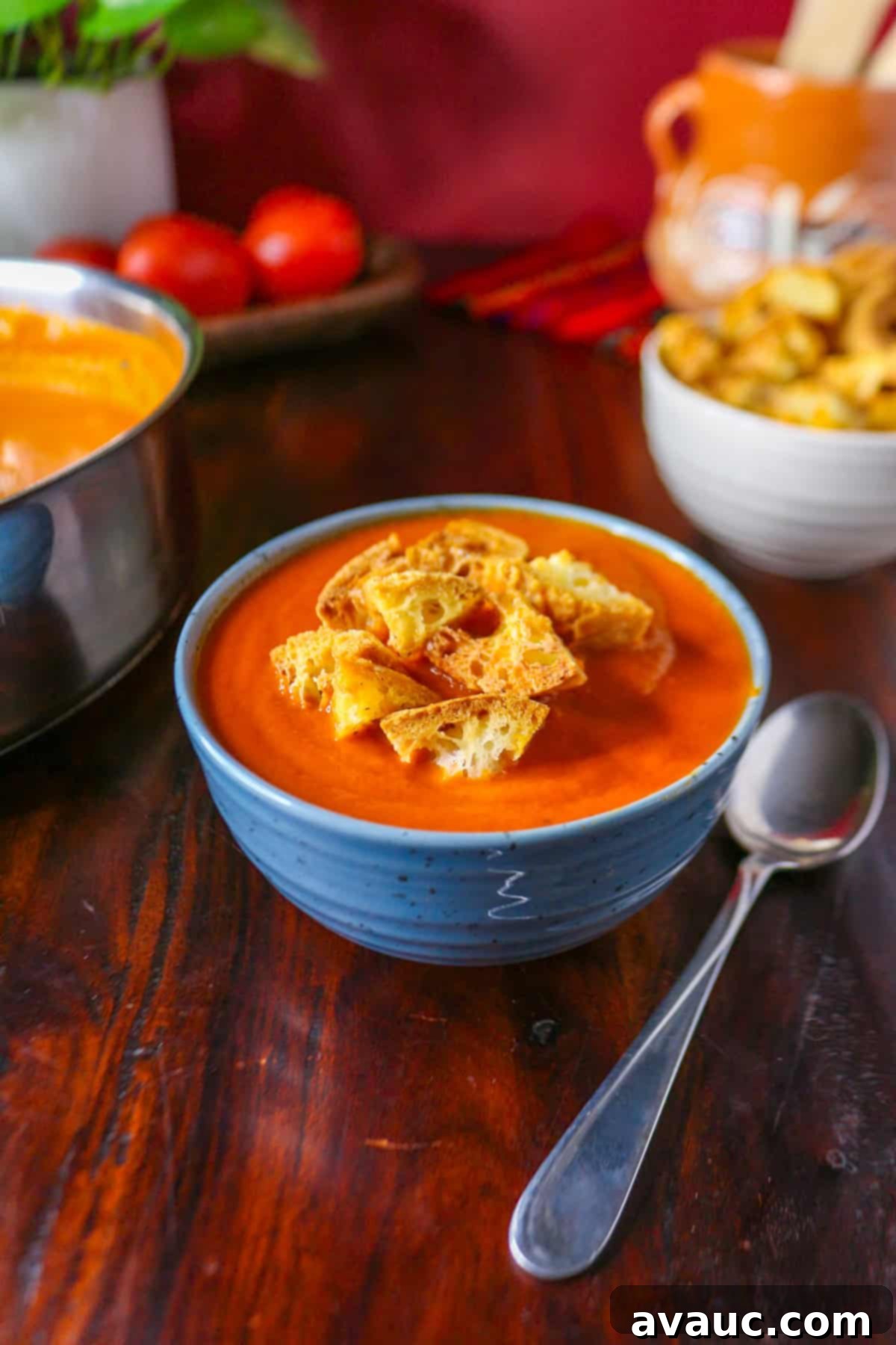 Spiced Chipotle Tomato Soup with Garlic Croutons 2 A bowl of Chipotle Tomato soup topped with croutons with a spoon beside it