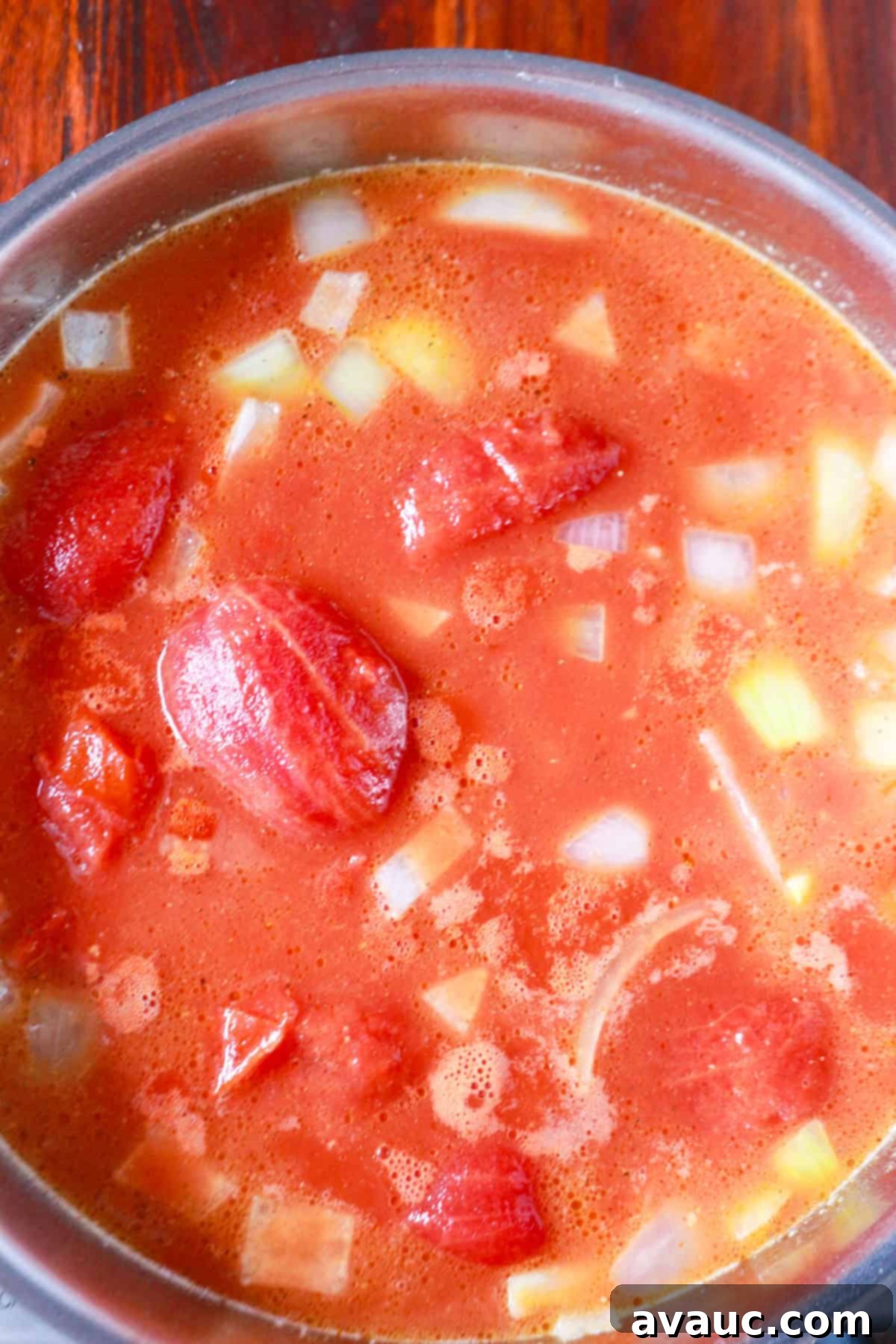 Spiced Chipotle Tomato Soup with Garlic Croutons 5 Tomatoes, broth and other ingredients simmering in a pot for the soup