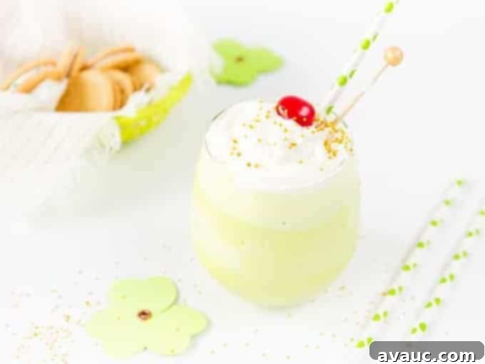 Two glasses of Shamrock Shake, one with gold sprinkles, the other with a cherry.