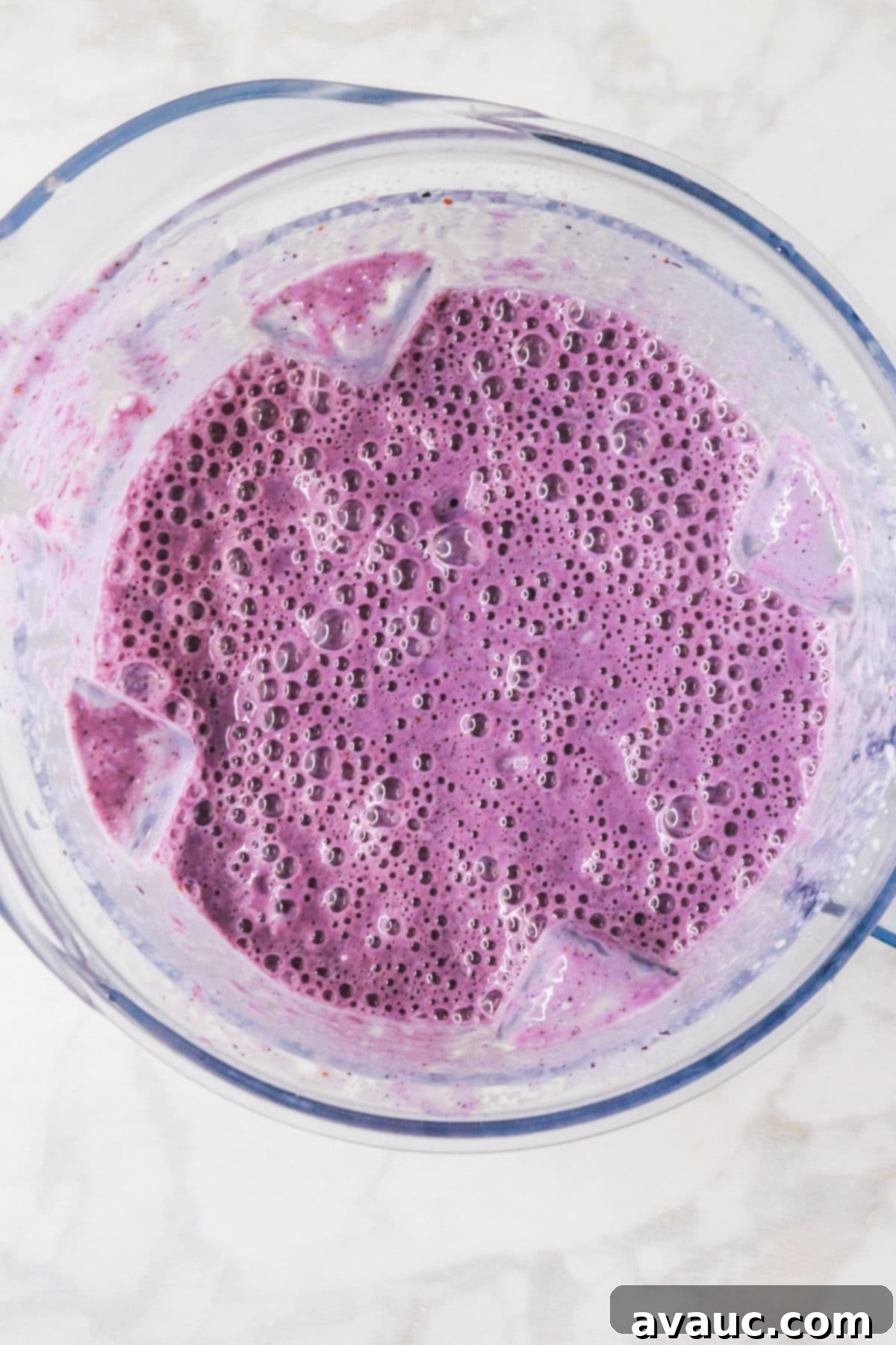 Dairy-Free Blueberry Velvet Agua Fresca 6 The blended mixture for creamy blueberry agua fresca, a smooth purple liquid, swirling inside a high-powered blender.