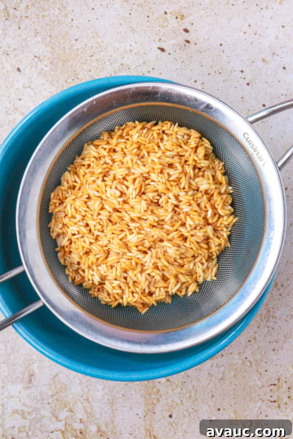 Toasted rice on a sieve over a bowl to drain the excess oil