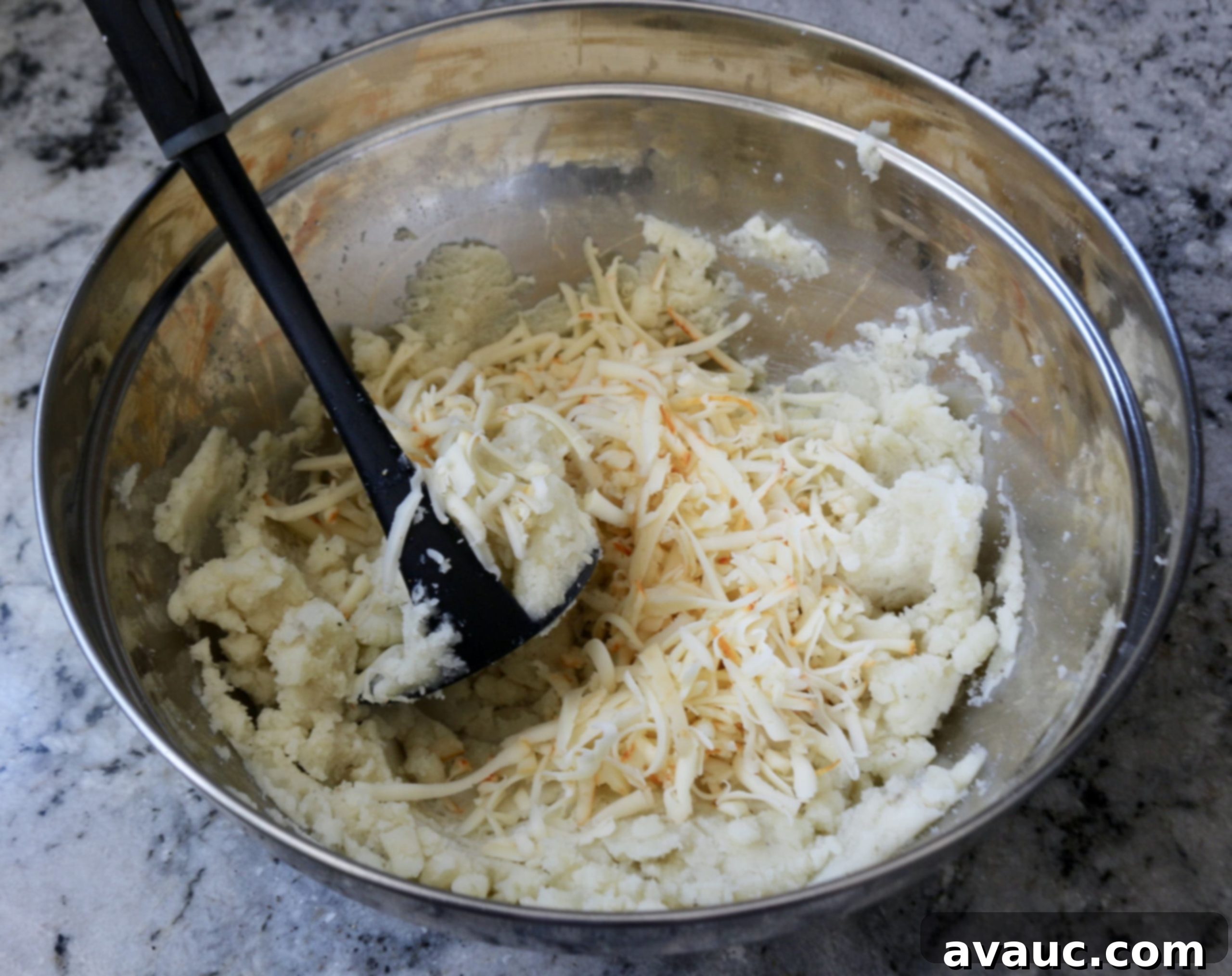 Mashing potatoes with cheese for potato patties with chile con queso