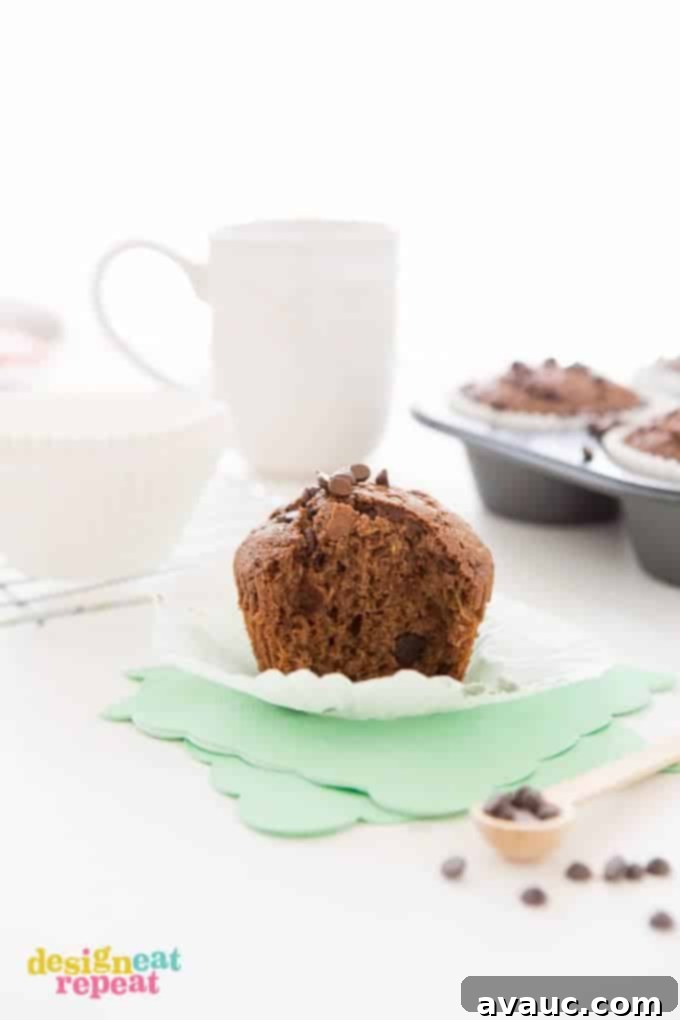 Chocolate Zucchini Muffin with bit taken out, placed on top of mint colored napkin.