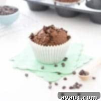 Decadent Double Chocolate Zucchini Muffins 9 Close-up of a Double Chocolate Zucchini Muffin showing its moist texture and chocolate chips.