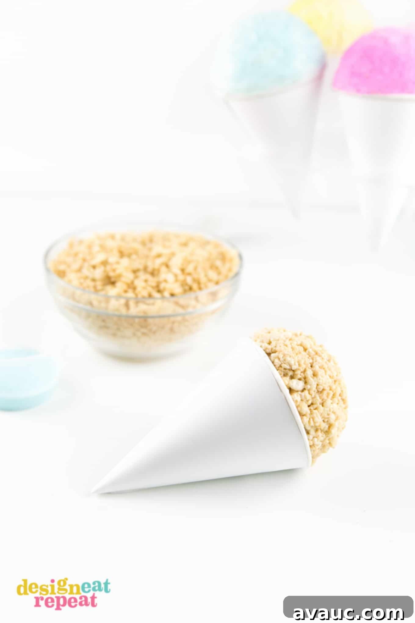 Hands pressing a ball of Rice Krispies mixture into a paper snow cone cup.