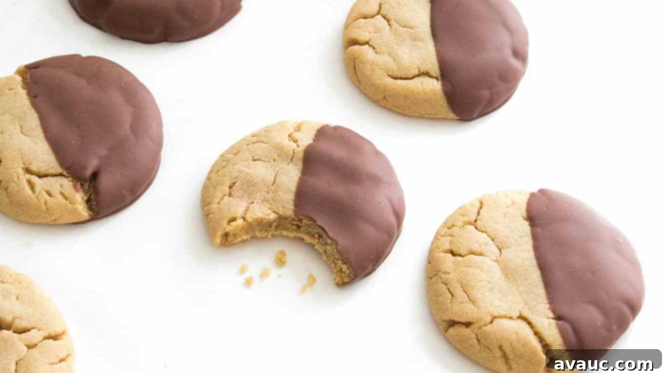 Bite taken out of peanut butter cookie dipped in chocolate.