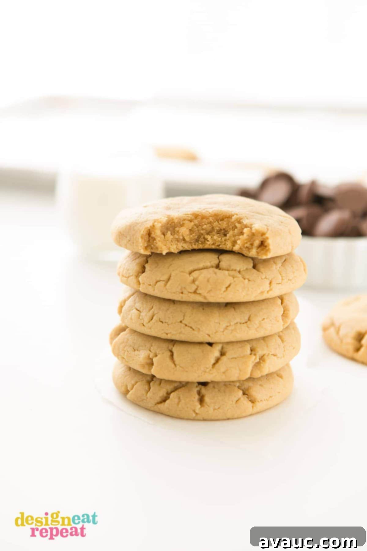 Stack of peanut butter cookies with bite taken out of top cookie.