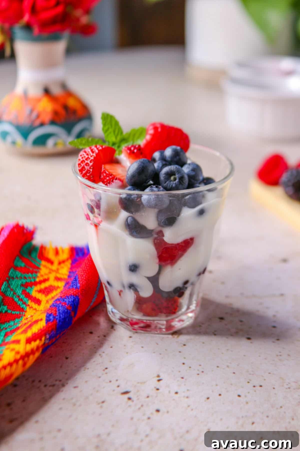 Luscious Dairy-Free Berries and Cream 2 Layers of colorful mixed berries and creamy dairy-free topping in a clear glass cup, showcasing the vibrant dessert.
