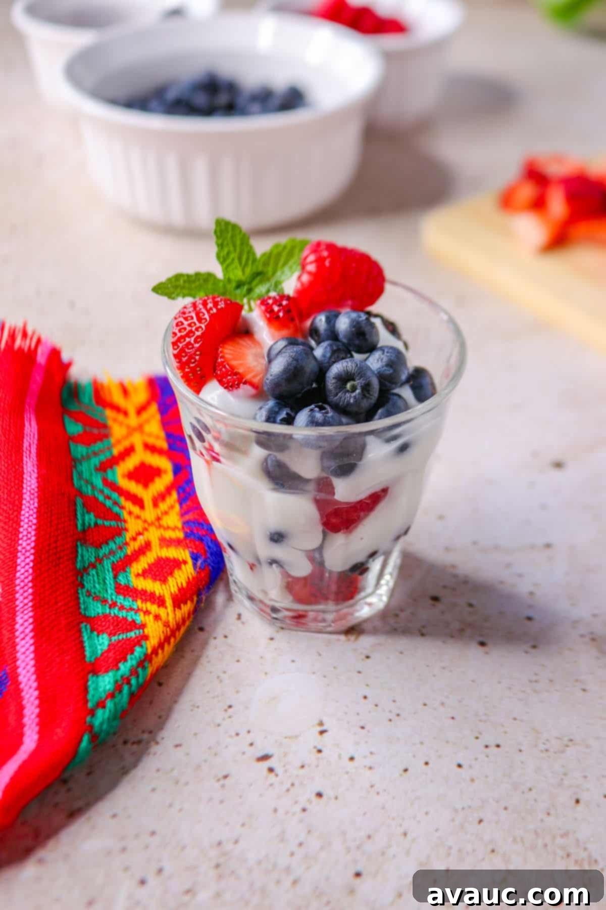 Luscious Dairy-Free Berries and Cream 7 A beautifully layered dairy-free berries with cream dessert in a clear glass cup, showing alternating layers of fresh mixed berries and smooth, white cream, ready to be enjoyed.