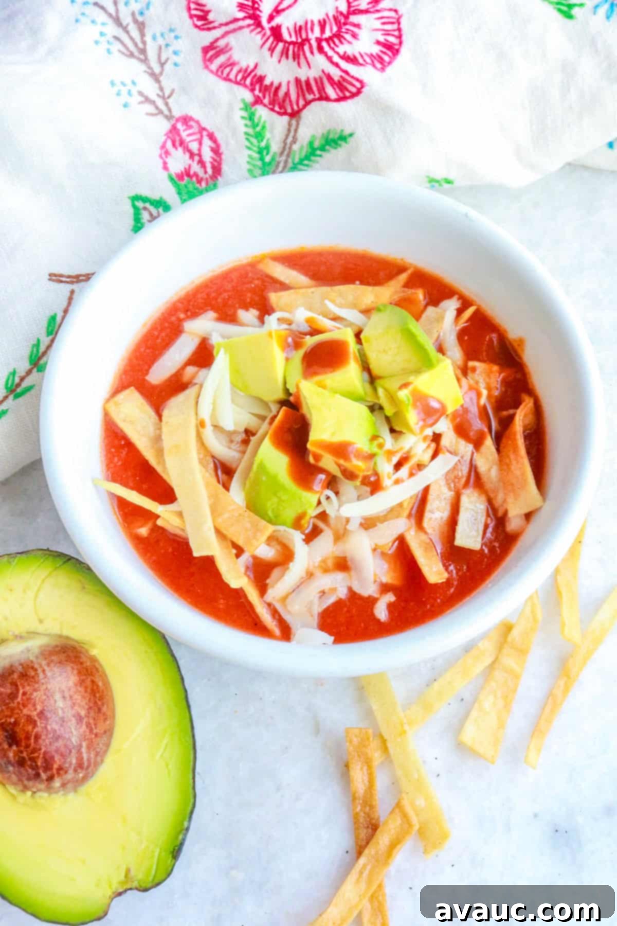 Aztec Tortilla Soup 11 A delicious bowl of Sopa de Tortilla Azteca, seen from the side, showcasing the rich tomato broth, crunchy tortilla strips, creamy avocado, and melted cheese toppings.