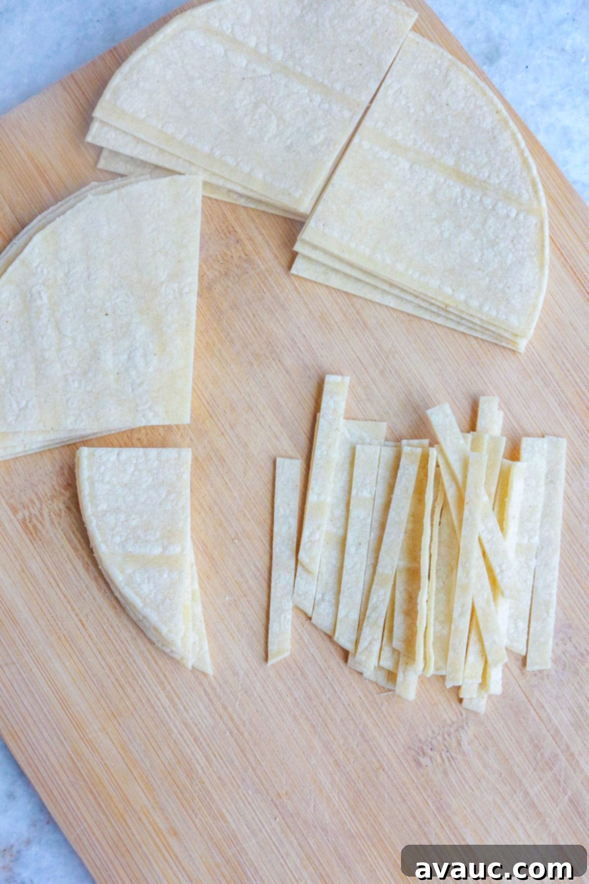 Aztec Tortilla Soup 4 Corn tortillas being expertly cut into thin strips, ready for frying to become crispy tortilla toppings for Sopa de Tortilla.