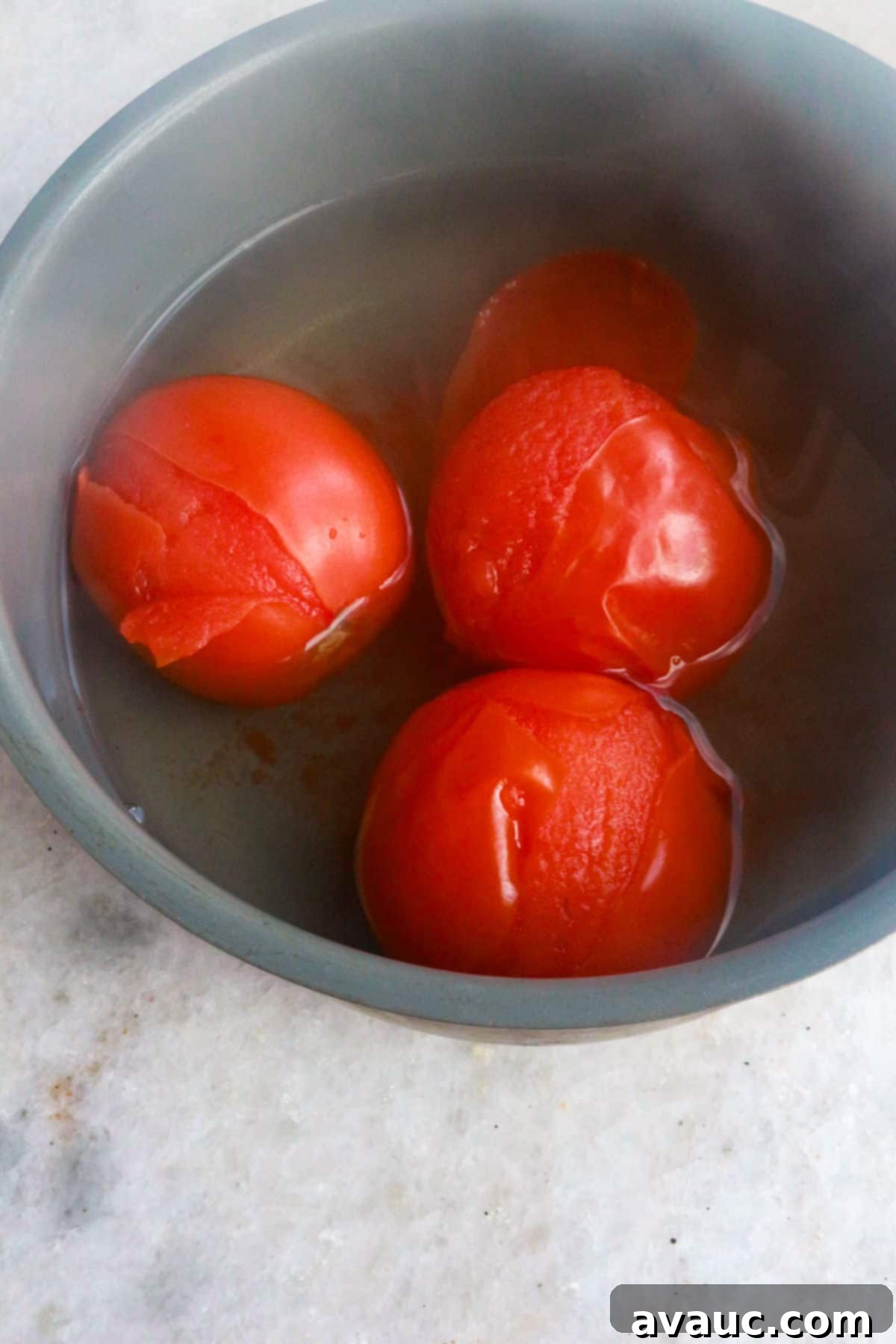 Aztec Tortilla Soup 7 Roma tomatoes boiling in water, softening before being peeled and blended for the smooth tomato broth of the tortilla soup.