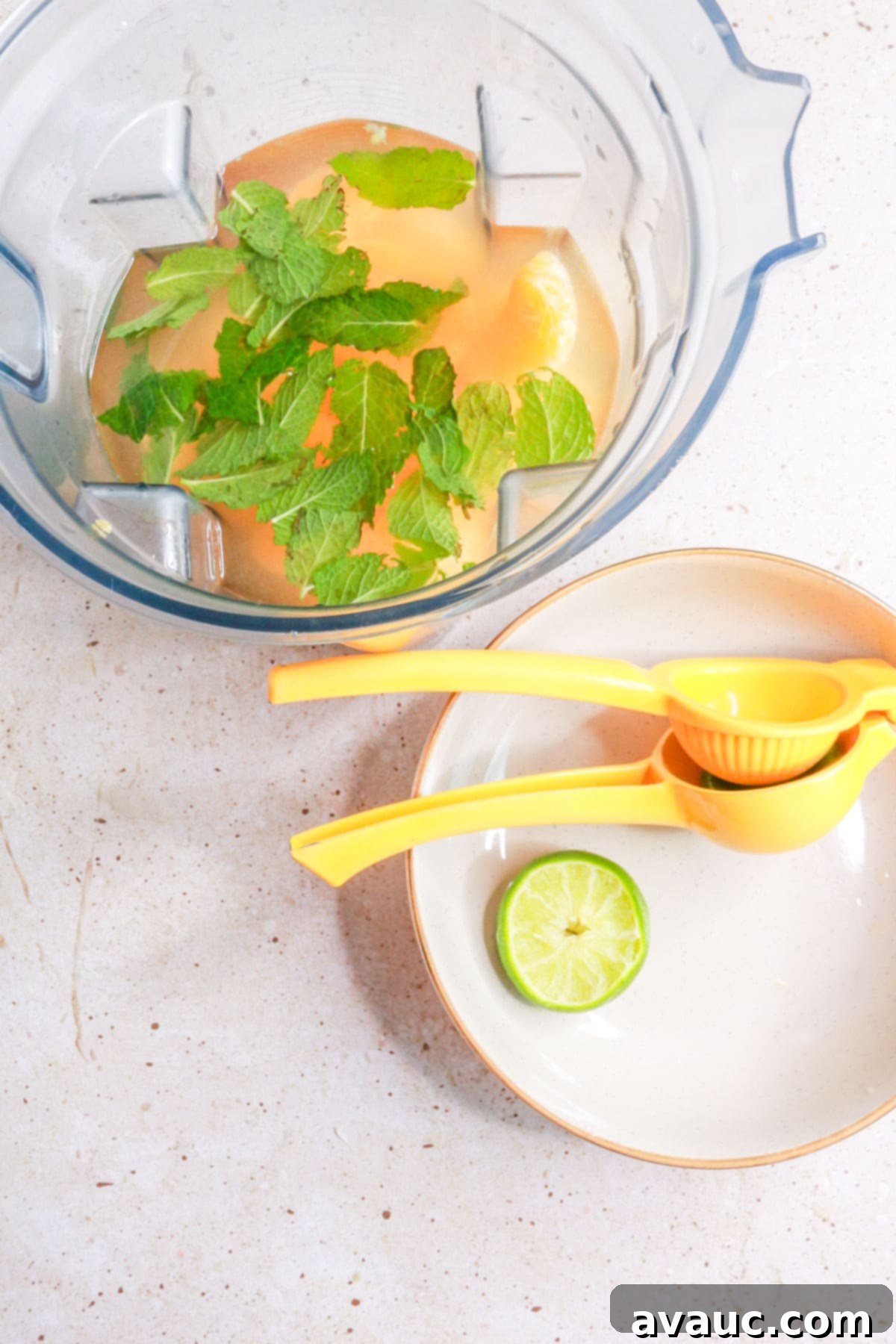 Refreshing Mandarin Mint Agua Fresca 5 a blender with water, mandarins, and mint with a plate beside it with a lime