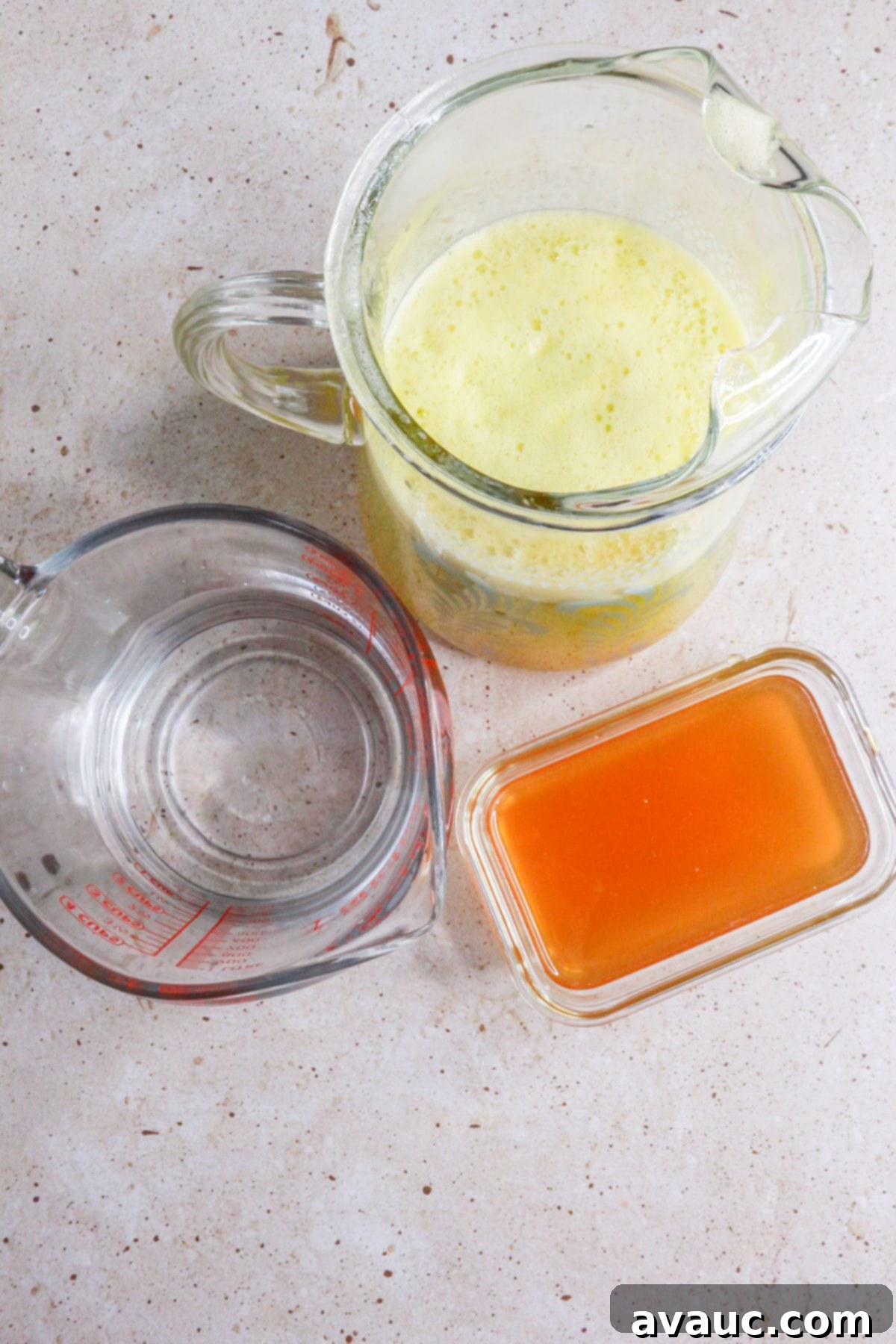 Refreshing Mandarin Mint Agua Fresca 8 a pitcher with mandarin agua fresca, a measuring cup with water and a container with honey simple syrup