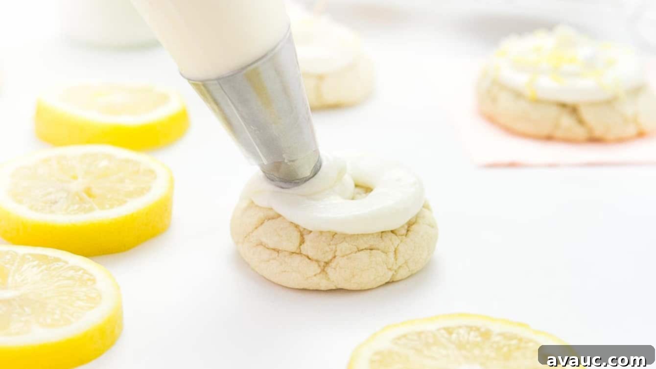 Luscious Lemon Cloud Cookies 2 Piping bag and tip piping cream cheese frosting onto thick lemon sugar cookie, showcasing the creamy texture.