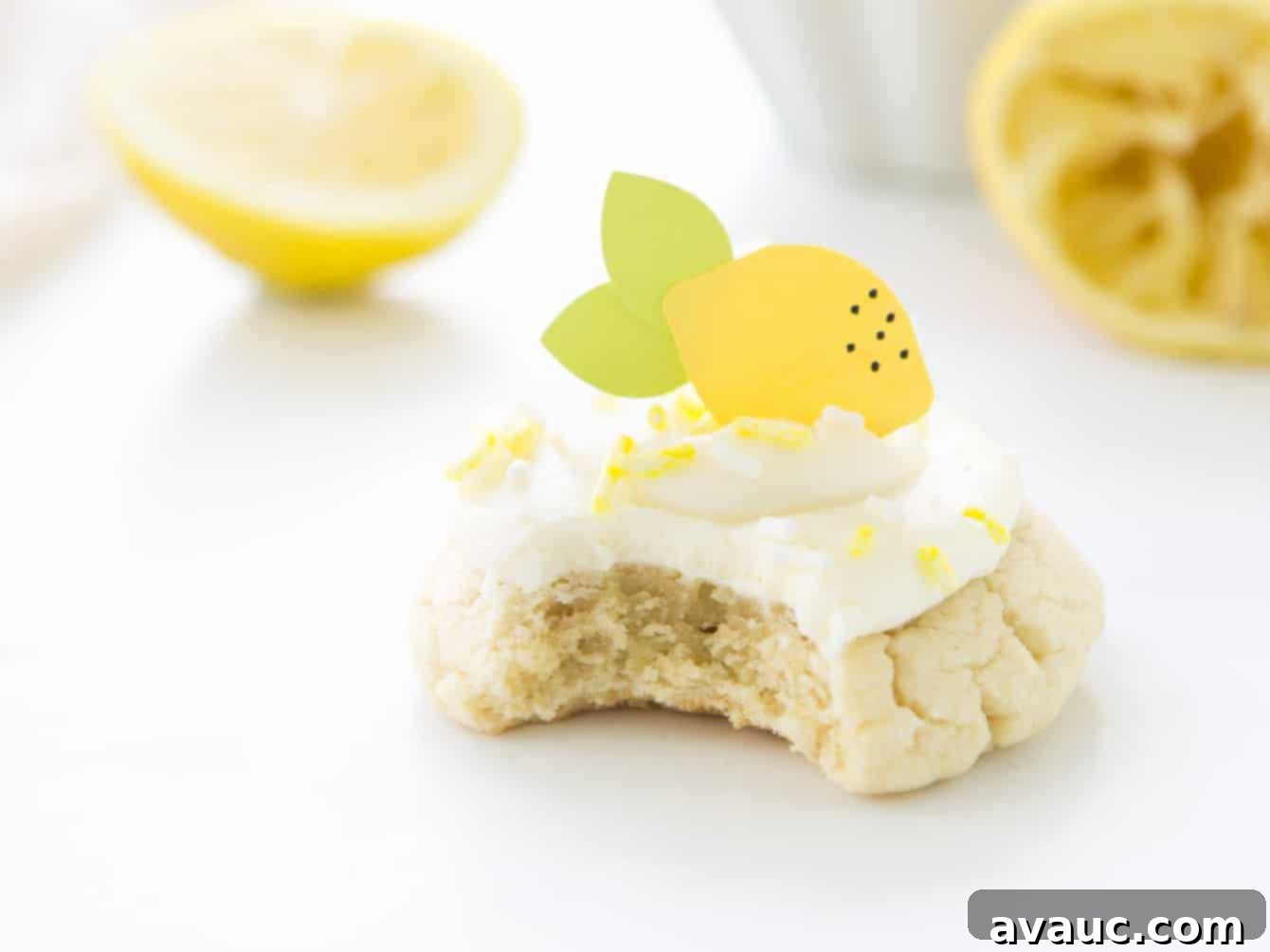 Luscious Lemon Cloud Cookies 8 Close-up of a lemon sugar cookie with cream cheese frosting, with a bite taken out to reveal the soft, thick interior.