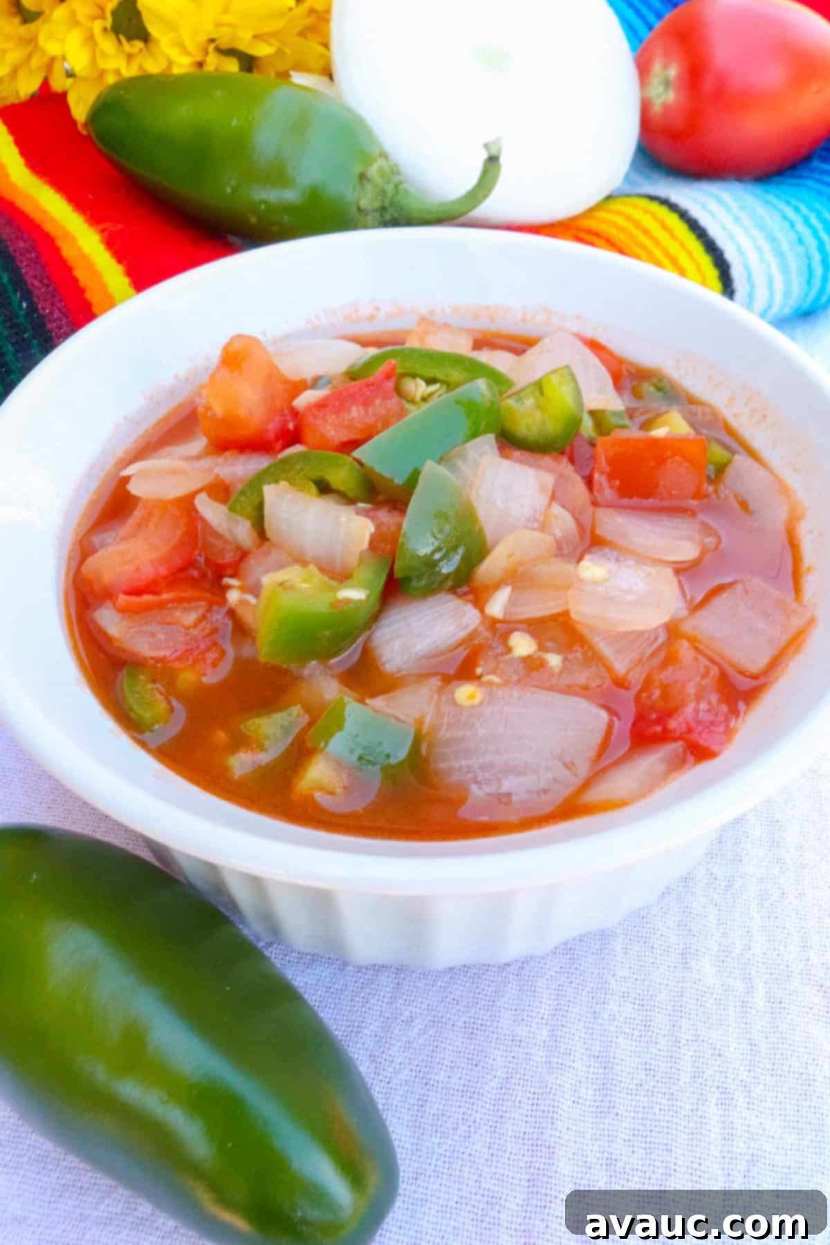 Side view of homemade chunky salsa in a white bowl, showing its rich texture and vibrant colors