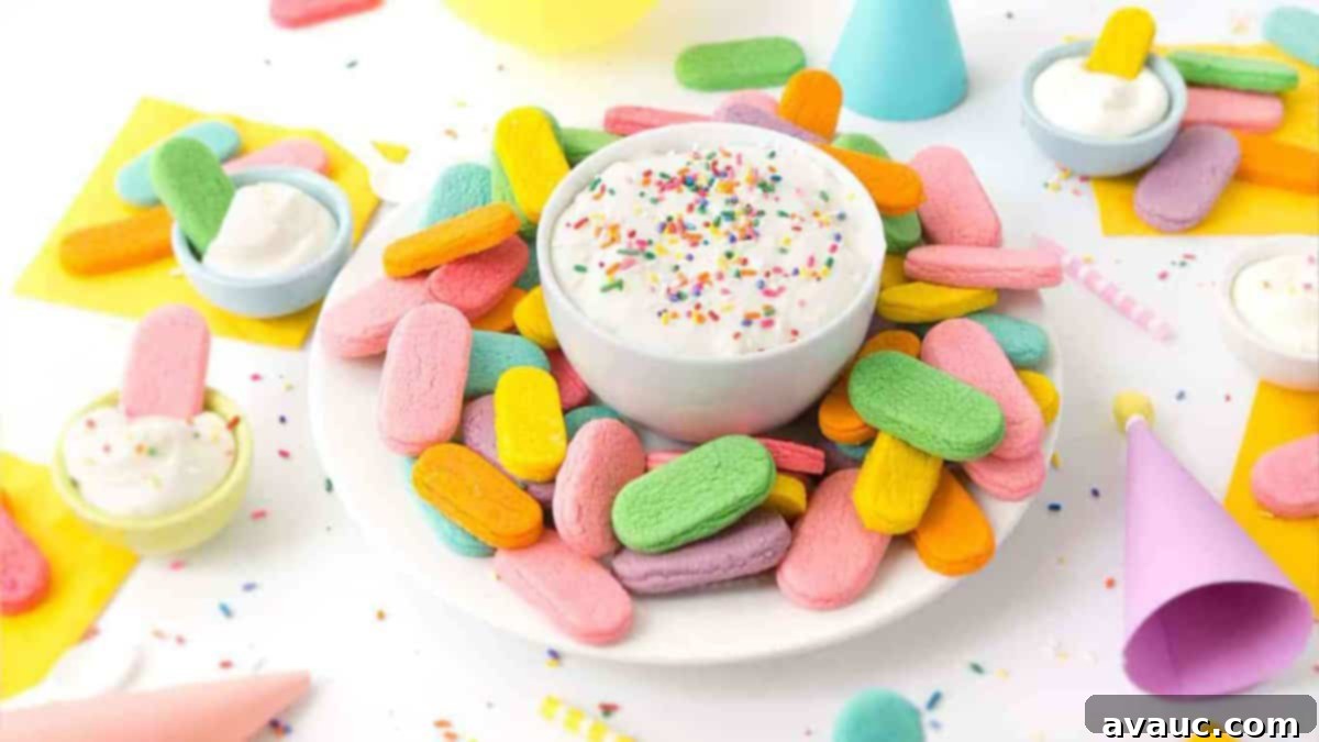 Plate of rainbow sprinkle sugar cookies with a bowl of cream cheese frosting in a party scene.
