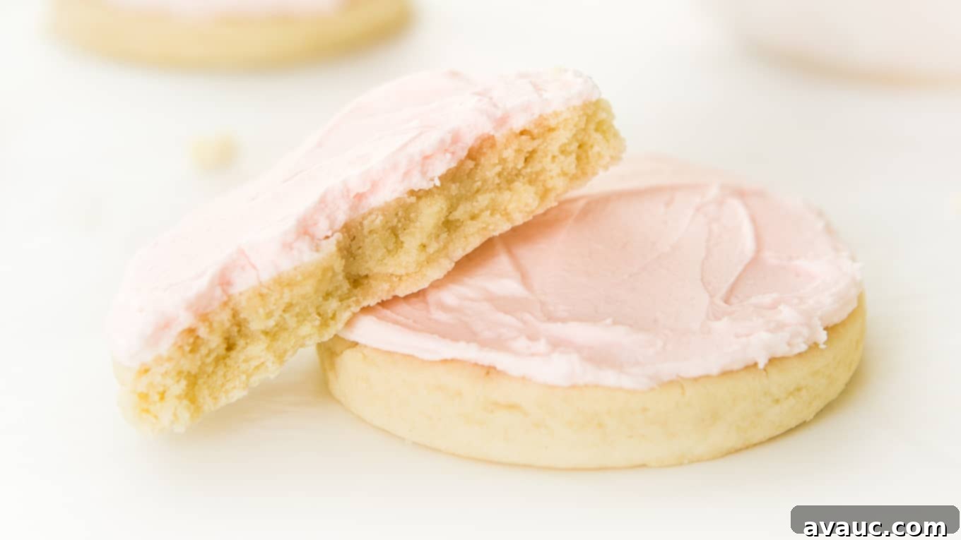 Blush Pink Sugar Clouds 3 Stack of two large, frosted pink sugar cookies, one with a bite taken out, showing the soft cookie texture.