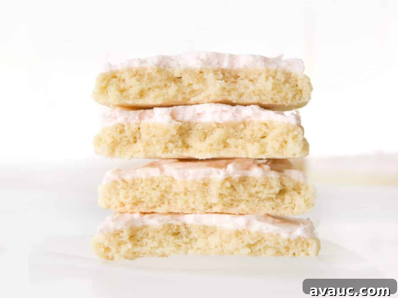 Blush Pink Sugar Clouds 6 Stack of two large, frosted pink sugar cookies, cut in half to reveal their thick, soft interior.