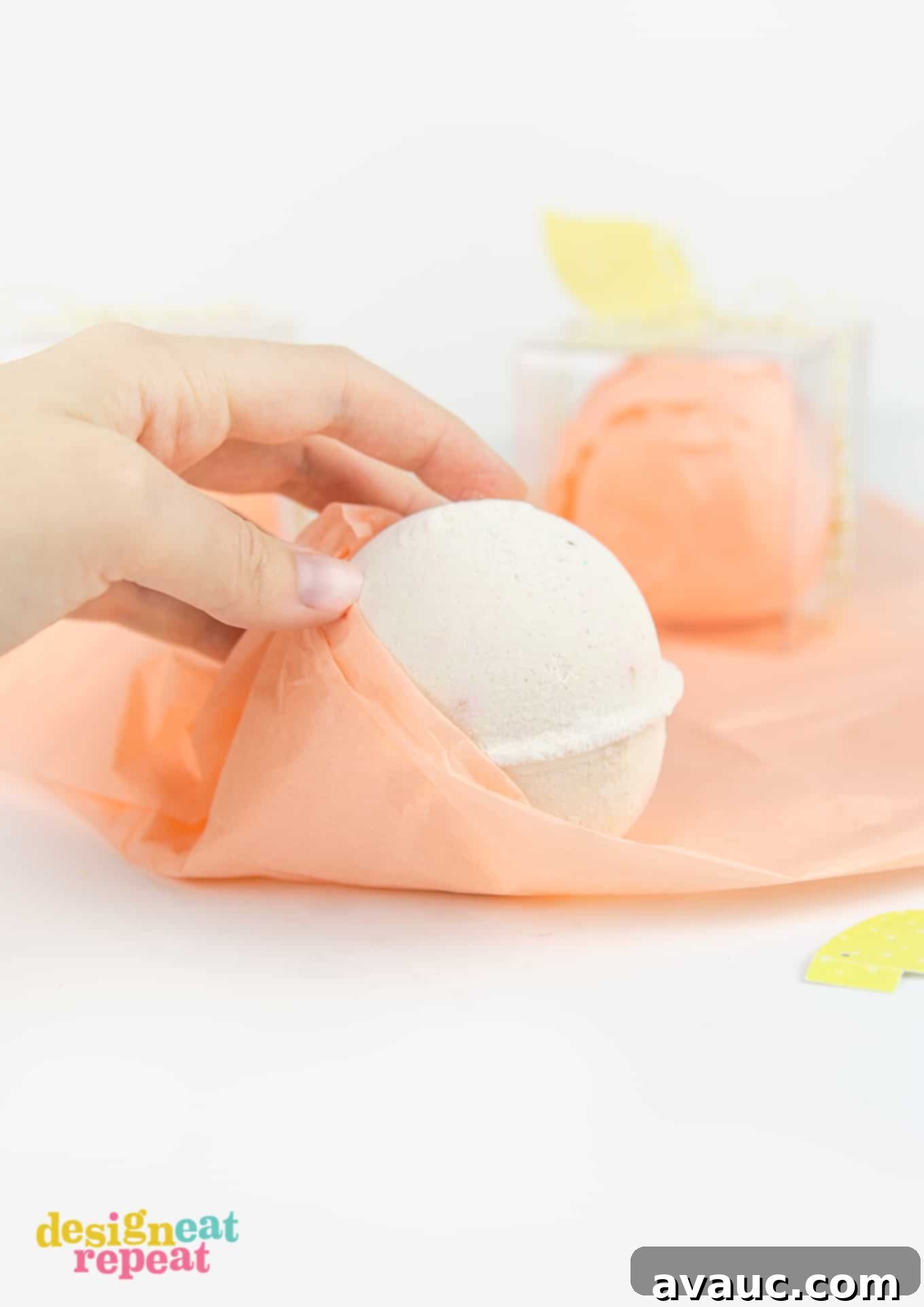 The materials needed for the DIY peach bath bomb gift boxes laid out, including clear boxes, bath bombs, and peach tissue paper.