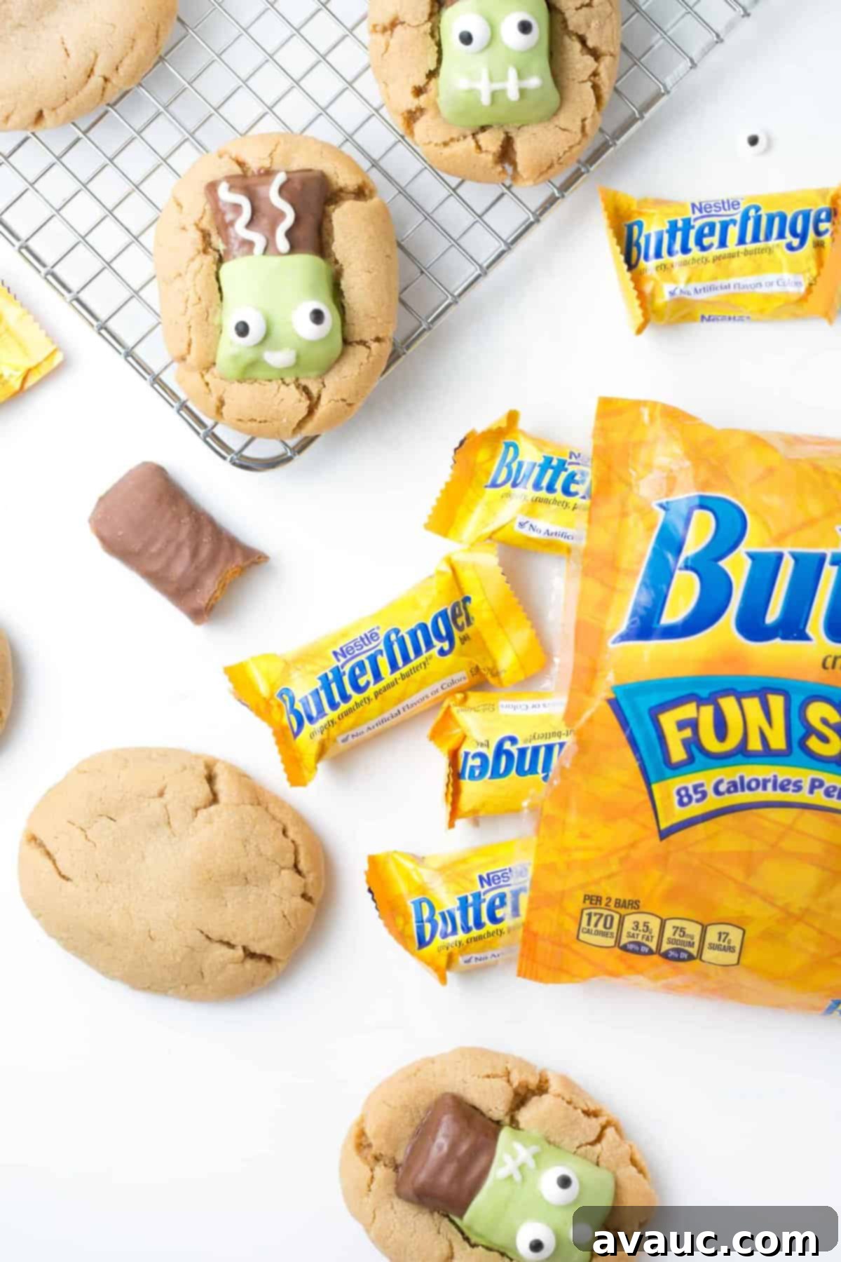 Open bag of Butterfinger fun size candy bars with peanut butter cookies on wire rack decorated to look like Frankenstein.