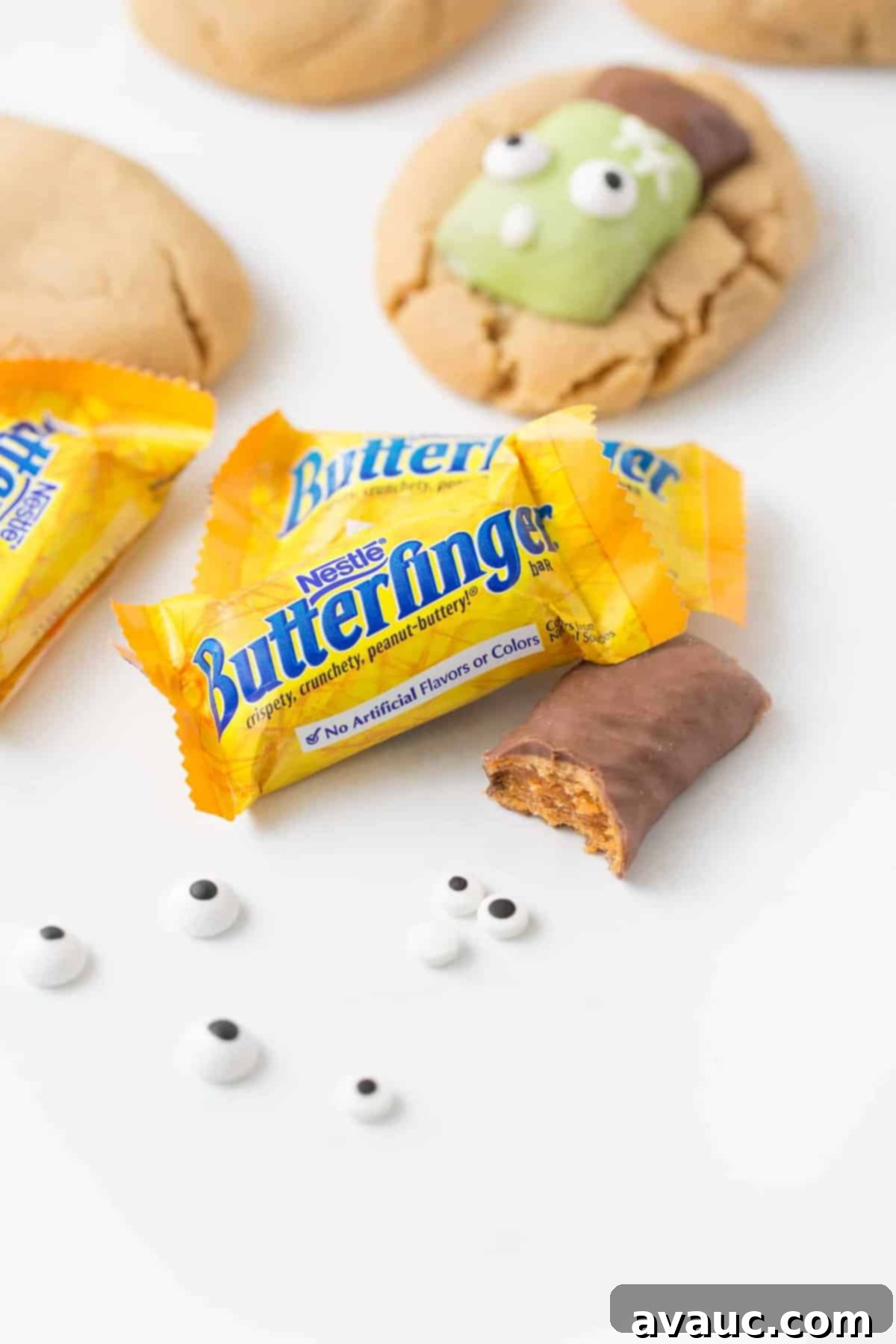 Close of shot of Butterfinger fun size candy bars with one bite of unwrapped candy bar. 