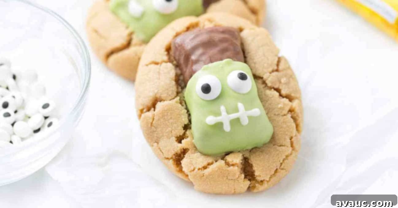 Close up shot of peanut butter cookies topped with Butterfinger fun size candy bars that have been decorated to look like Frankenstein.