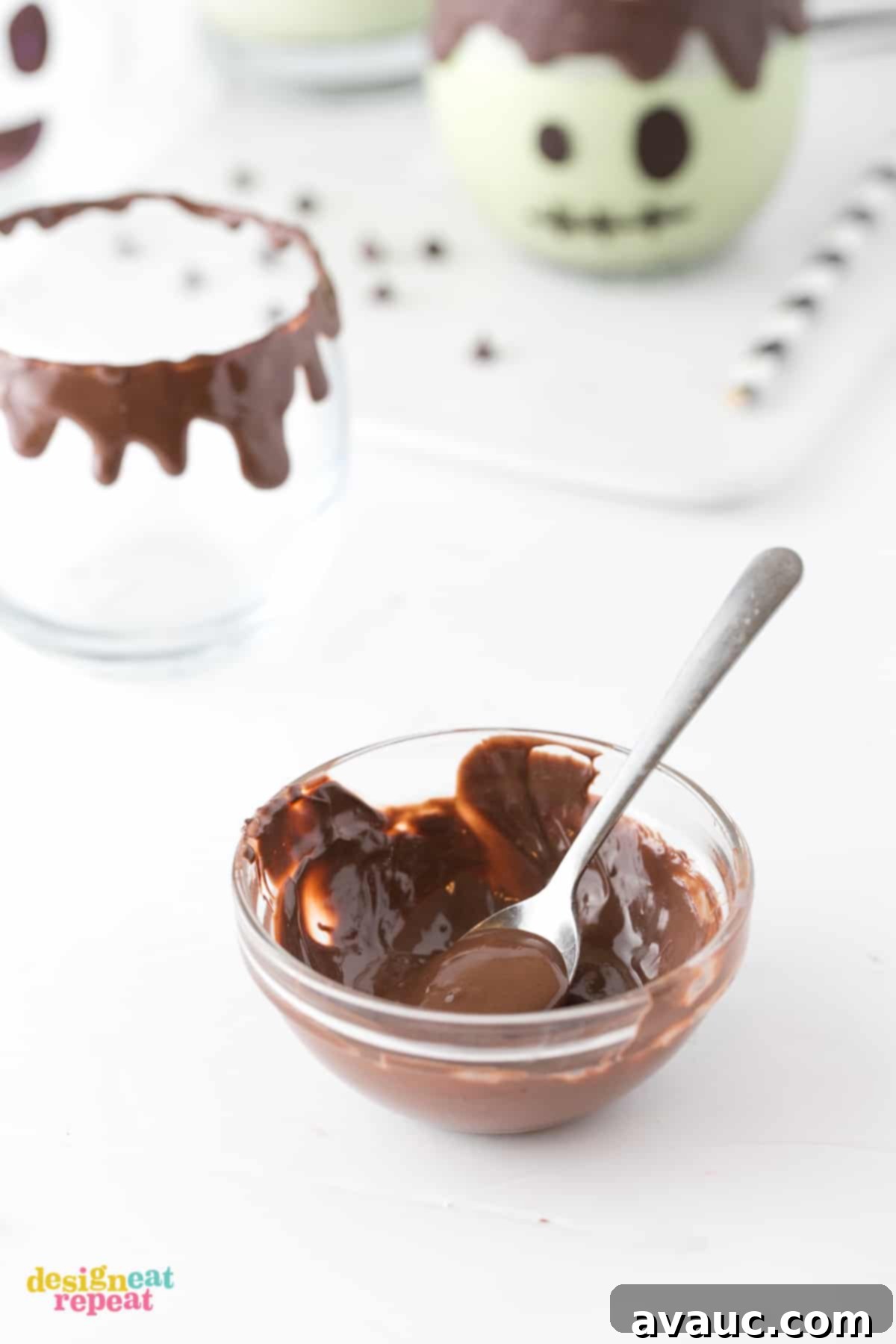 Melting chocolate for Frankenstein Milkshake drip Bowl of melted dark chocolate with small spoon piping on rim of glass. Frankenstein Halloween Milkshakes