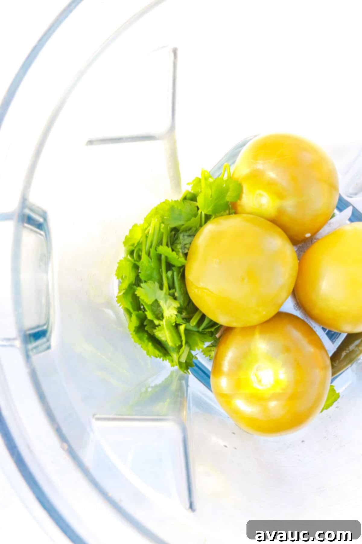 tomatillos, cilantro and other ingredients for salsa in a blender