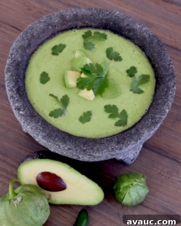 Vibrant Fresh Tomatillo Salsa with Avocado, bright green and smooth, in a molcajete.