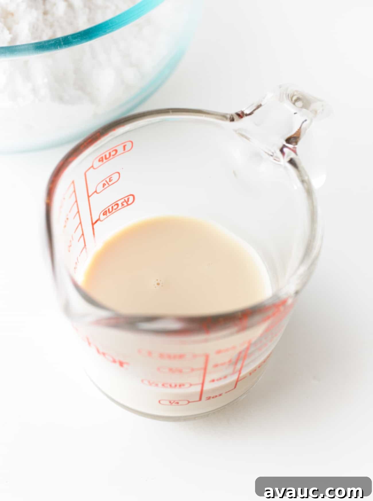 Pyrex glass measuring cup with evaporated milk to make fudgy, easy chocolate frosting.