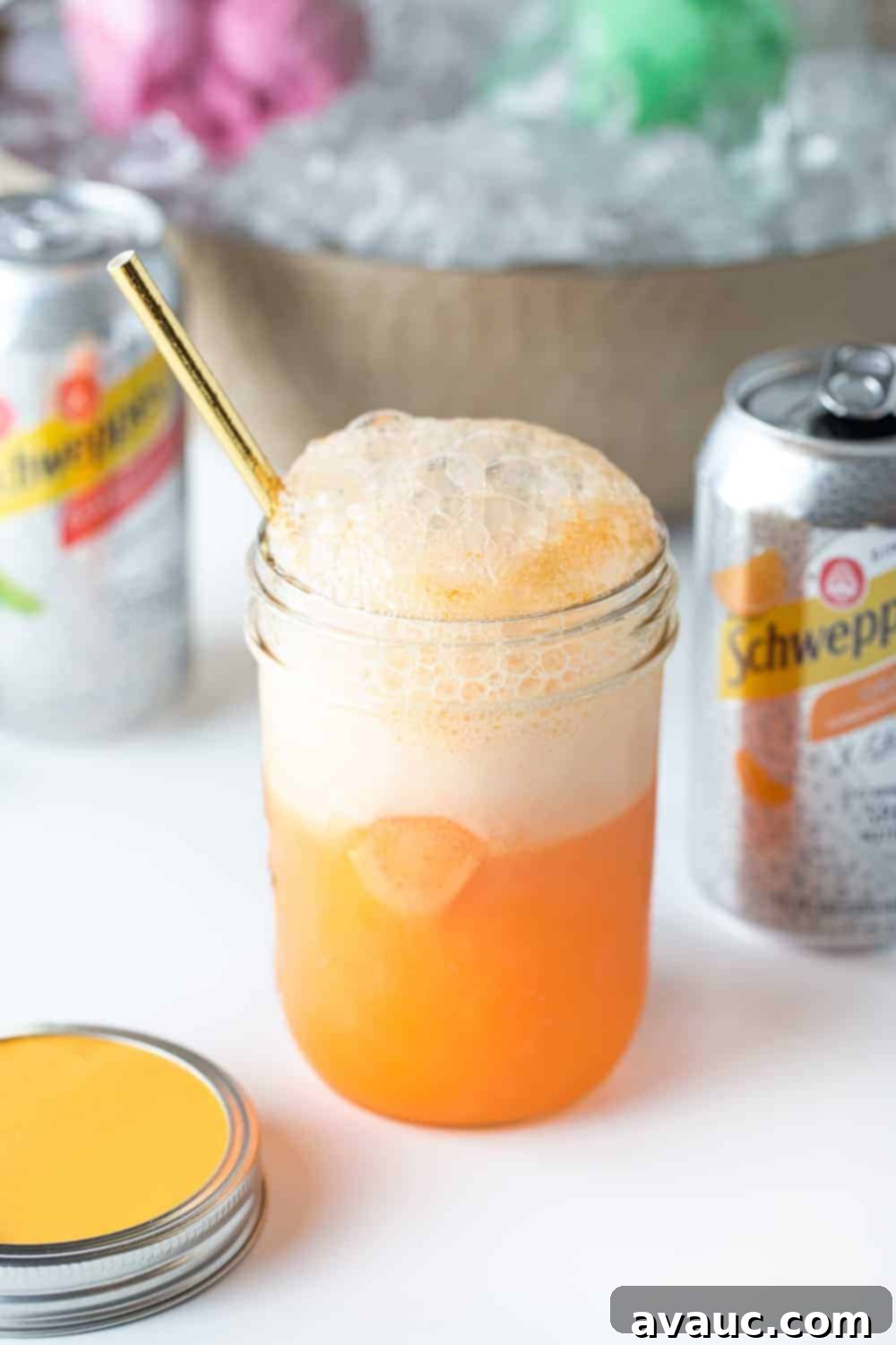 A glass of carbonated, fizzing orange sherbet punch garnished with an orange slice, part of the Ultimate DIY Punch Bar.